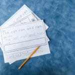 Arkusz z prostym zdaniem i ołówkiem na niebieskim tle dla początkujących