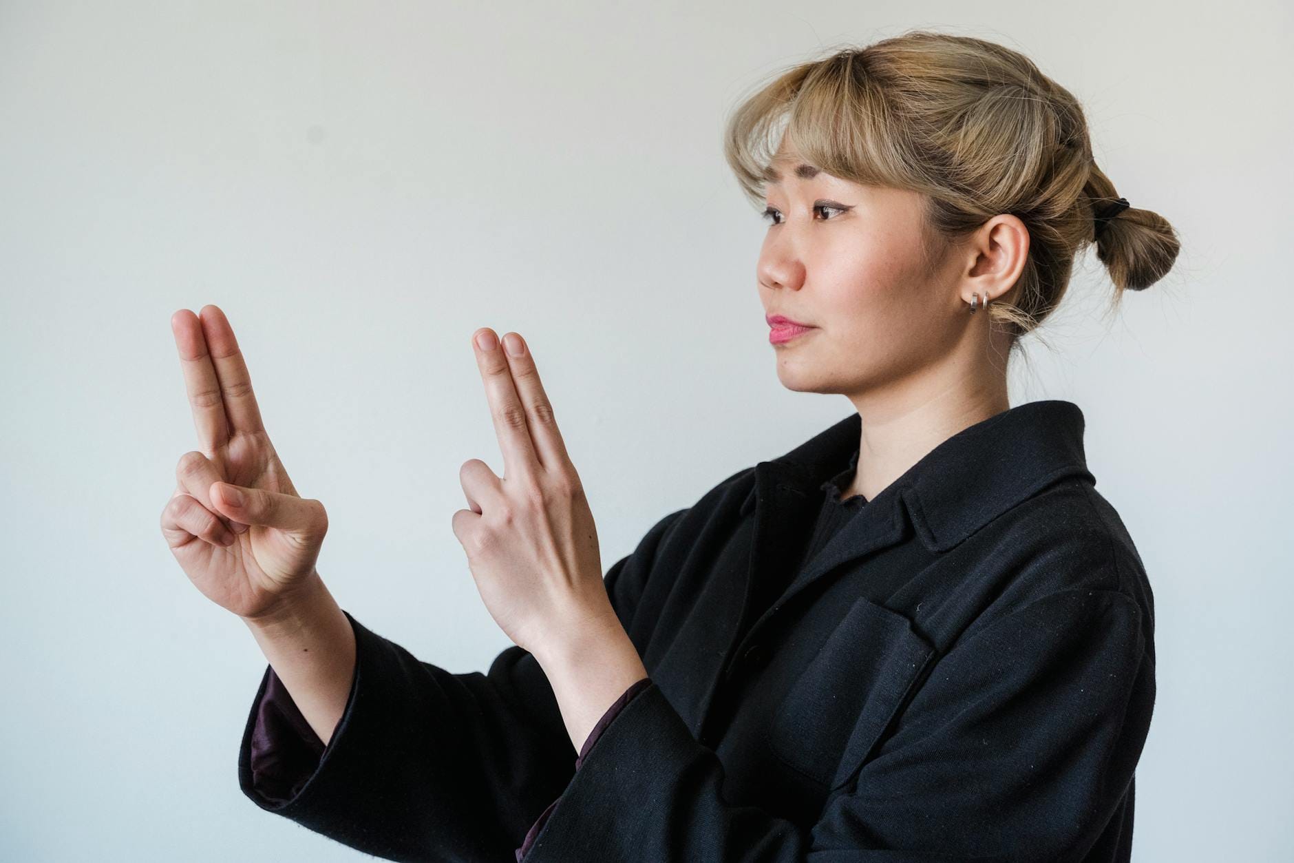 Fałszywi przyjaciele w tłumaczeniach PL EN Azjatka pokazująca gesty języka migowego na białym tle
