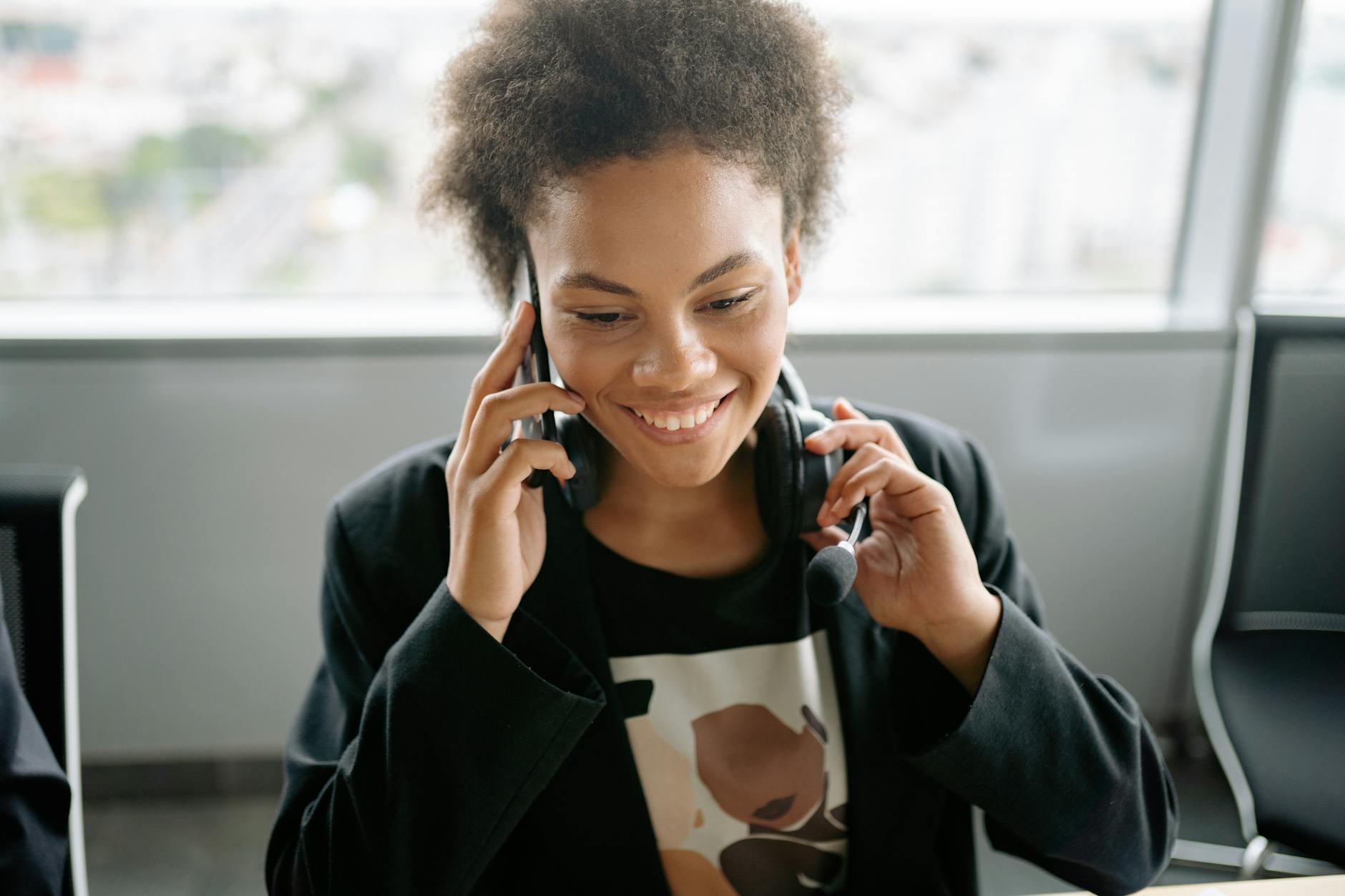 Uśmiechnięta konsultantka call center rozmawia przez telefon w słuchawce