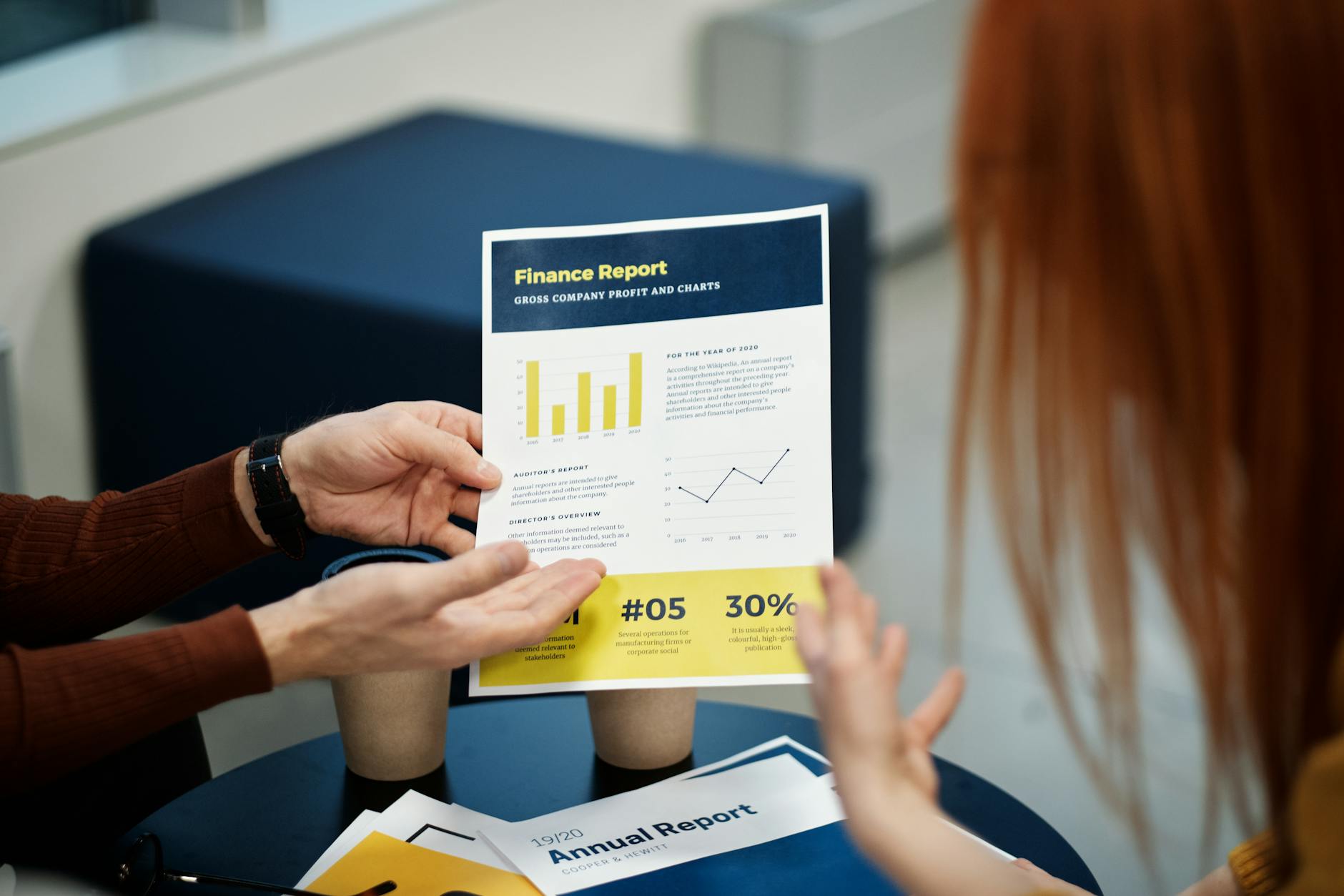 Dwie osoby analizują raport finansowy z wykresem w biurze