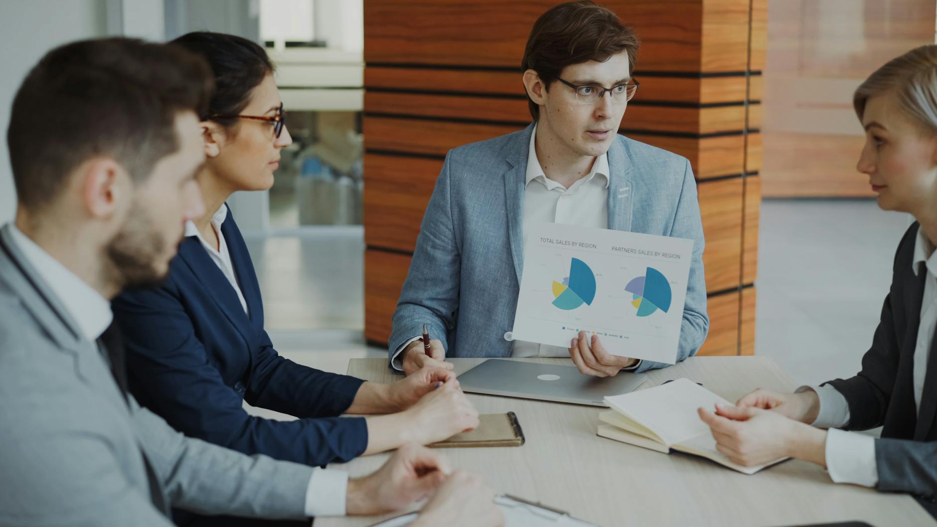Specjaliści omawiają wykresy i raporty podczas spotkania biznesowego