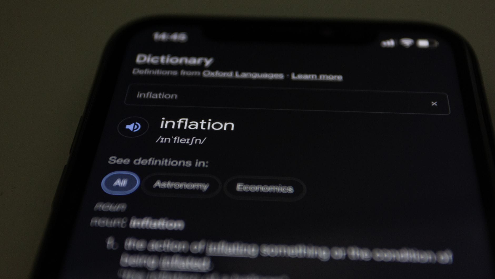 Czy można nauczyć się wymowy z YouTube? Fakty, błędy i dobre praktyki Zbliżenie smartfona z aplikacją słownika i definicją słowa inflation