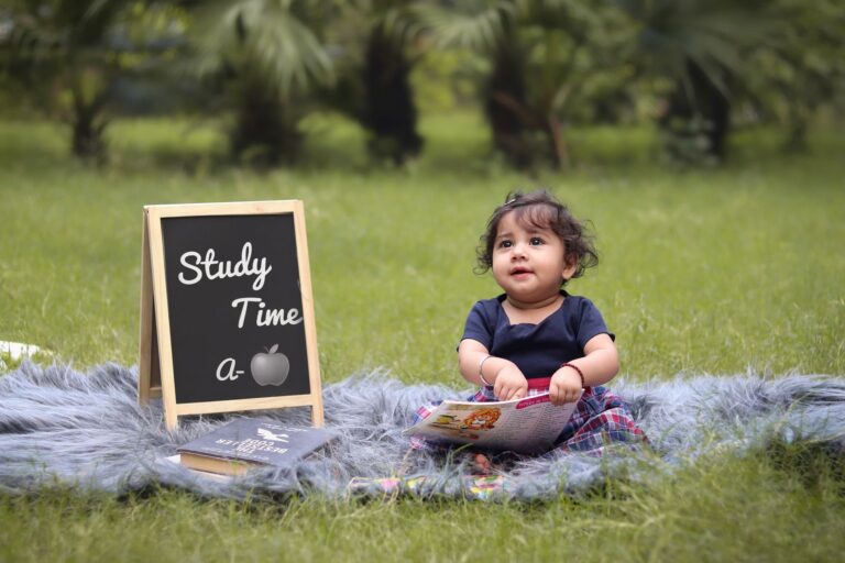 Niemowlę na kocu z książkami i tablicą Study Time A jak apple
